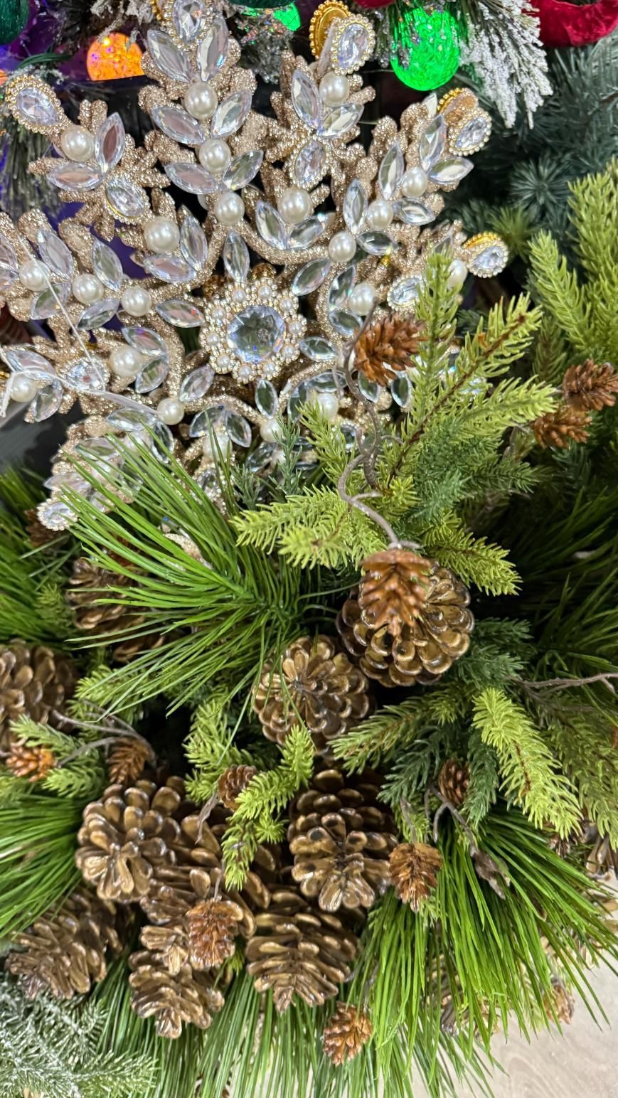 Close-up of a Christmas wreath with pine needles, pinecones, and silver decorative snowflakes. | Jingle Bell Christmas