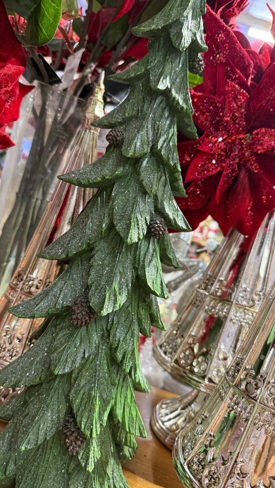 Green, glittery, decorative Christmas tree with red poinsettia and silver ornaments. | Jingle Bell Christmas