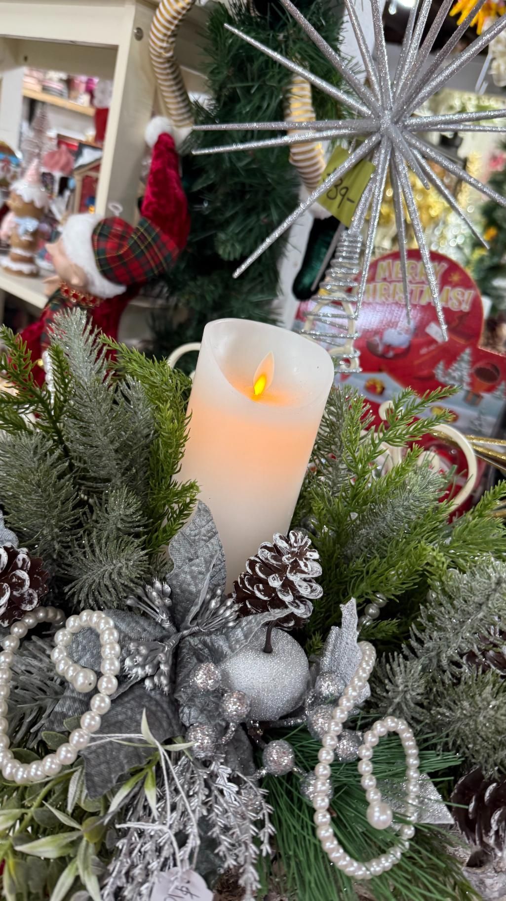 Christmas centerpiece with a lit candle, pine, and silver ornaments. | Jingle Bell Christmas