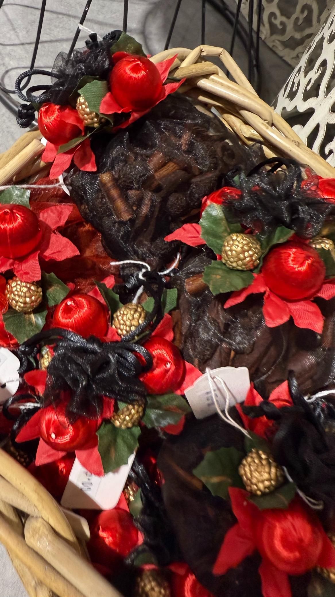 Basket filled with dark-colored food decorated with red apples, golden baubles, and black accents. | Jingle Bell Christmas