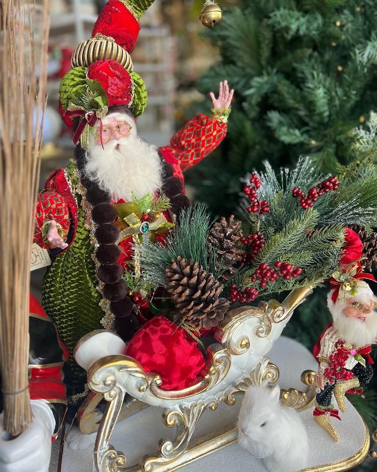 A Santa Claus Figurine is Sitting in a Sleigh With a Christmas Tree — Florets In Lismore, NSW