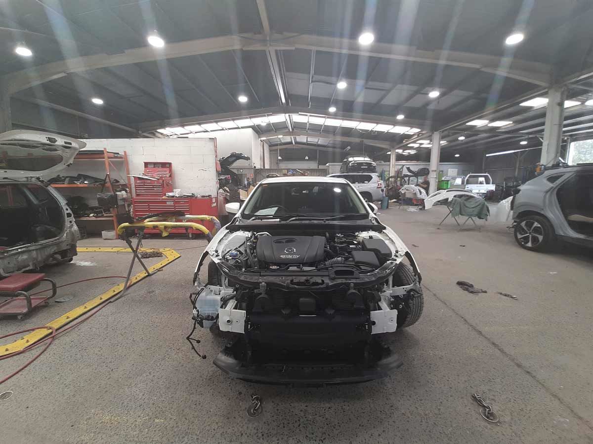 A White Car is Being Worked on in a Garage β Vanderpoel Smash Repairs in Tuggerah, NSW