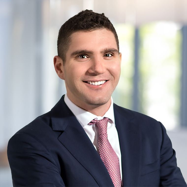 A man in a suit and tie is smiling for the camera