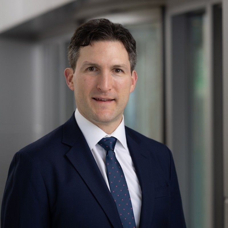 A man in a suit and tie is smiling for the camera.