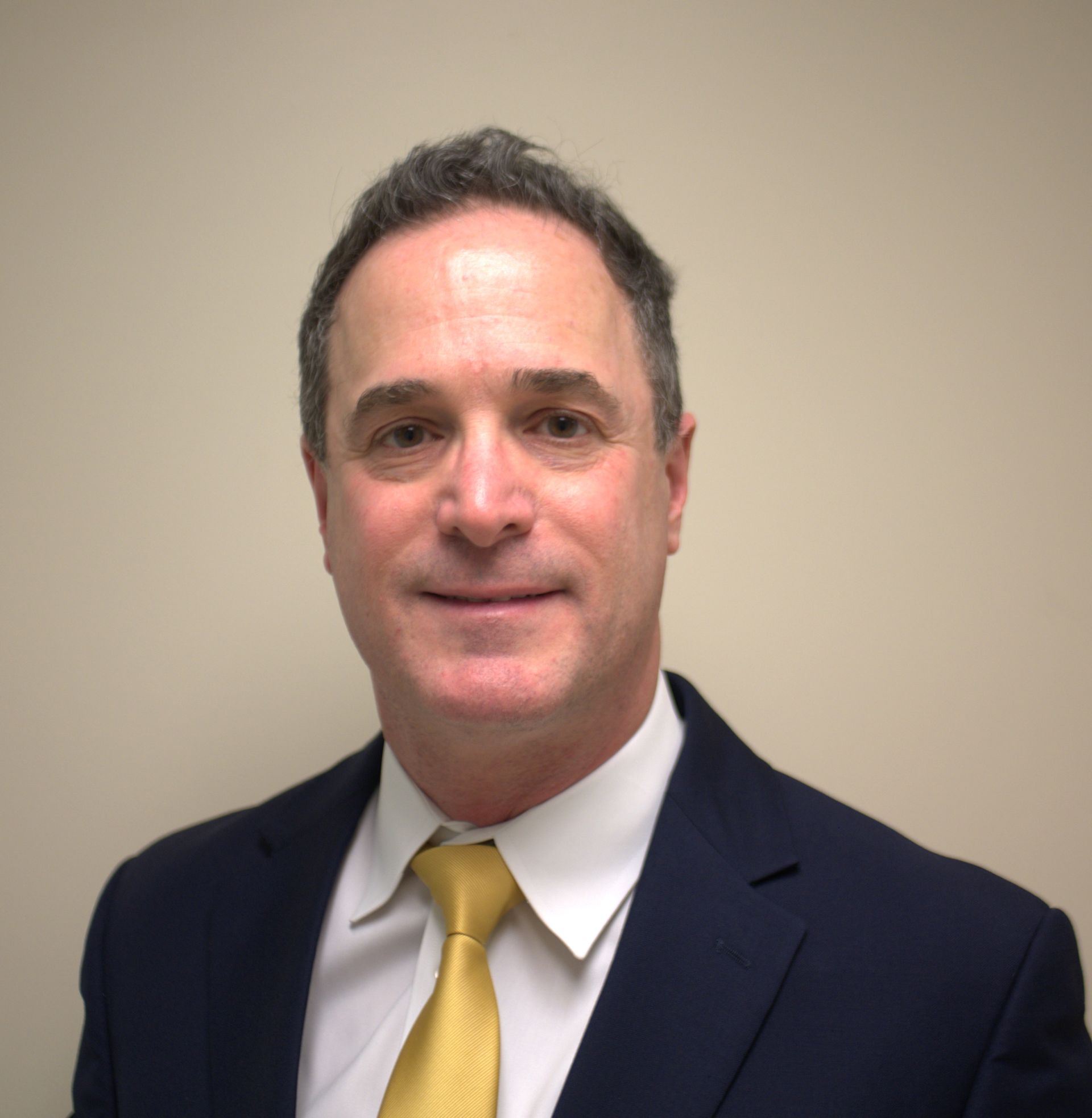 A man in a suit and tie is smiling for the camera
