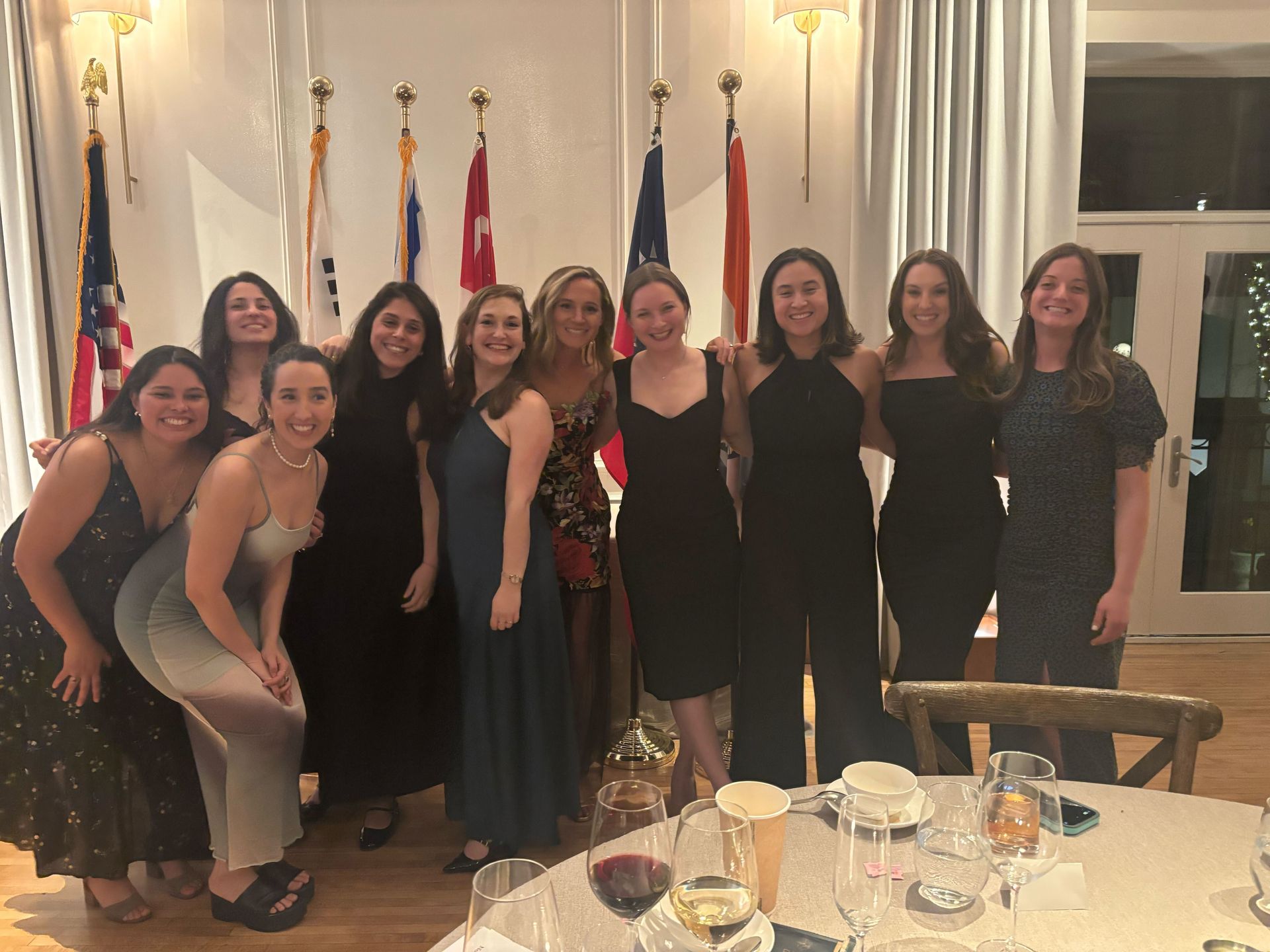 A group of women are posing for a picture in front of a table.