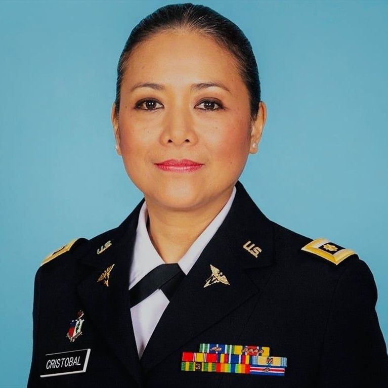 A woman in an u.s. army uniform is smiling