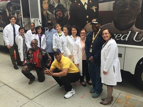 A group of people are posing for a picture in front of a bus.