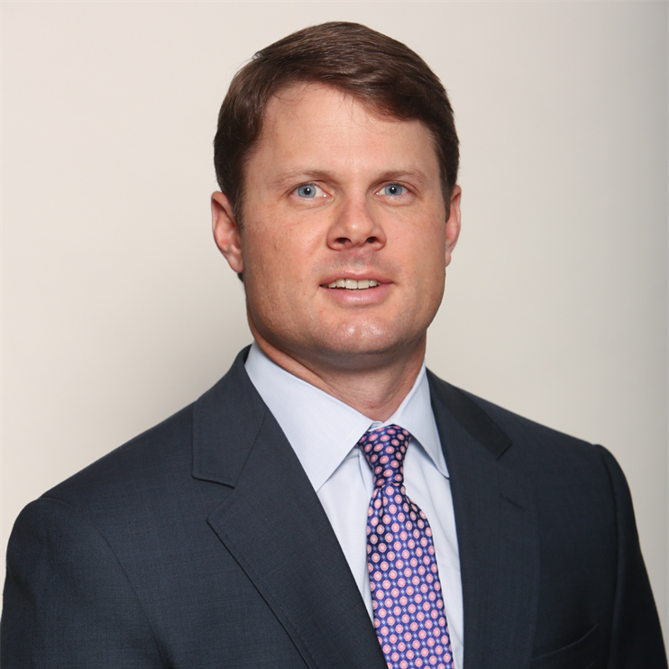 A man in a suit and tie is smiling for the camera