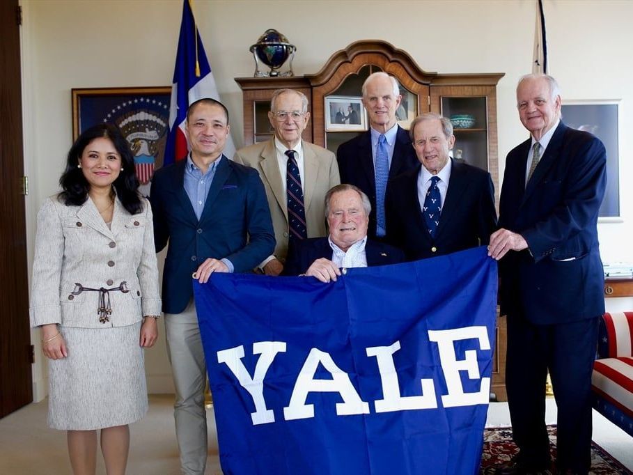 A group of people holding a yale flag