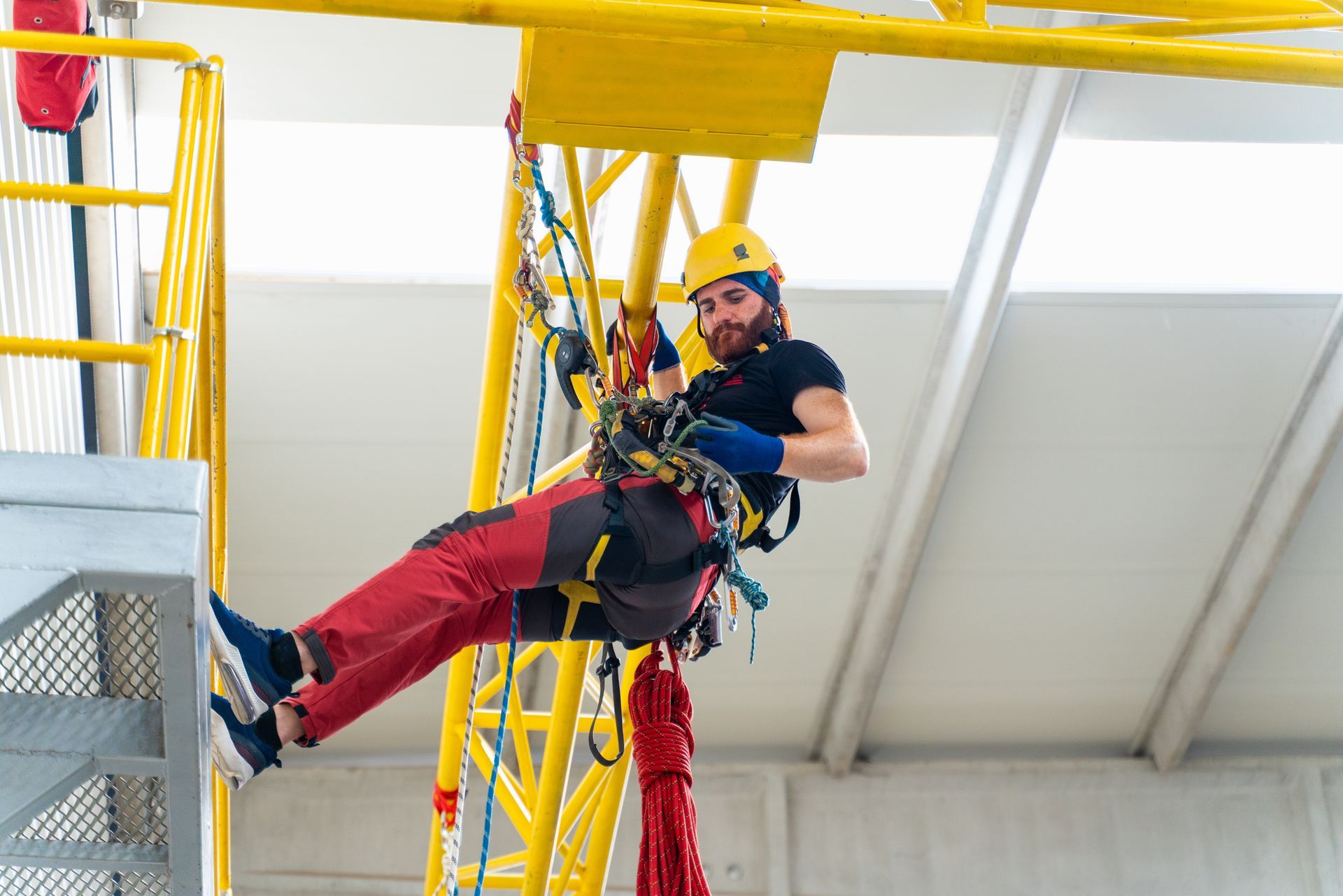 A man on a rope climbs a ladder, illustrating safety measures for working at heights training.