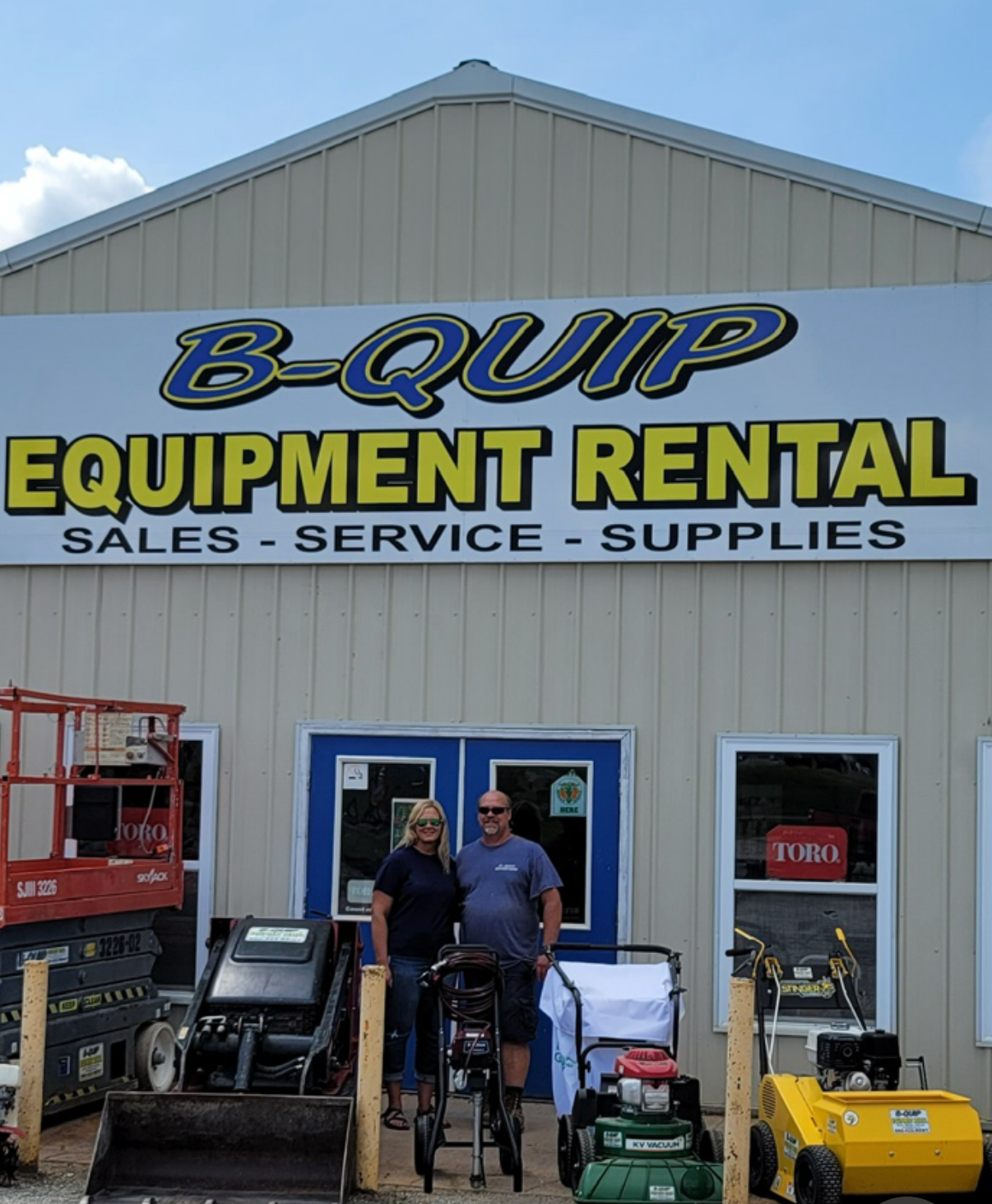 A couple standing in front of a b-quip equipment rental store