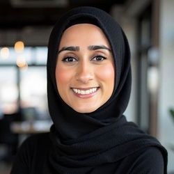 Smiling person in a black hijab indoors, with a blurred café-style background. Smiling person in a black hijab indoors, with a blurred café-style background.