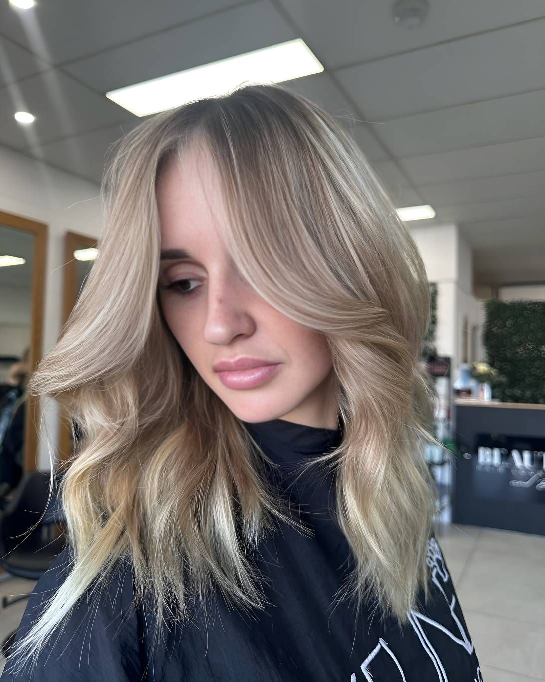 A Woman With Blonde Hair Is Standing — Beautique Hair Lounge & Beauty Bar In Townsville, QLD