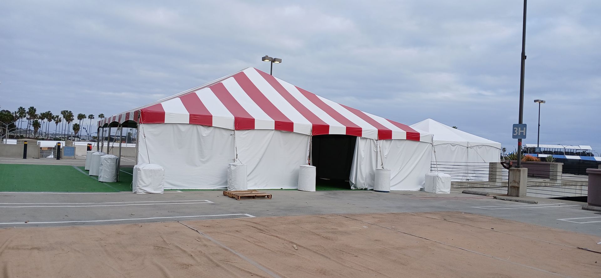 A white tent with a red and white striped roof