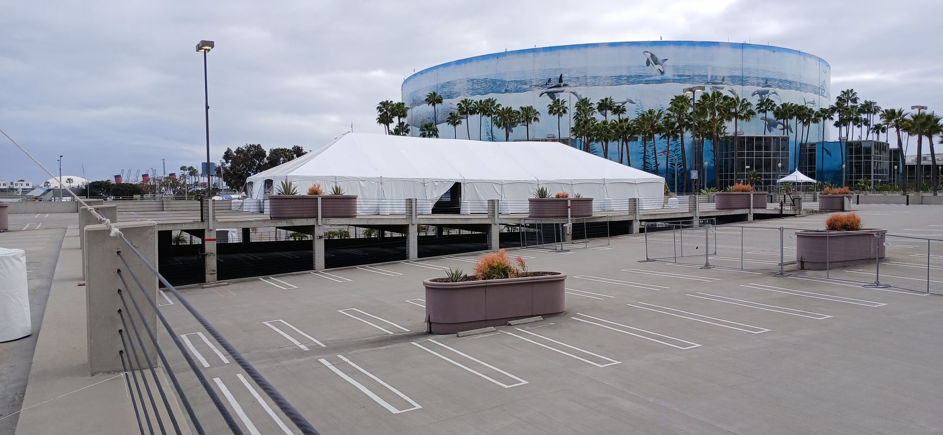A large white tent is sitting in the middle of a parking lot.