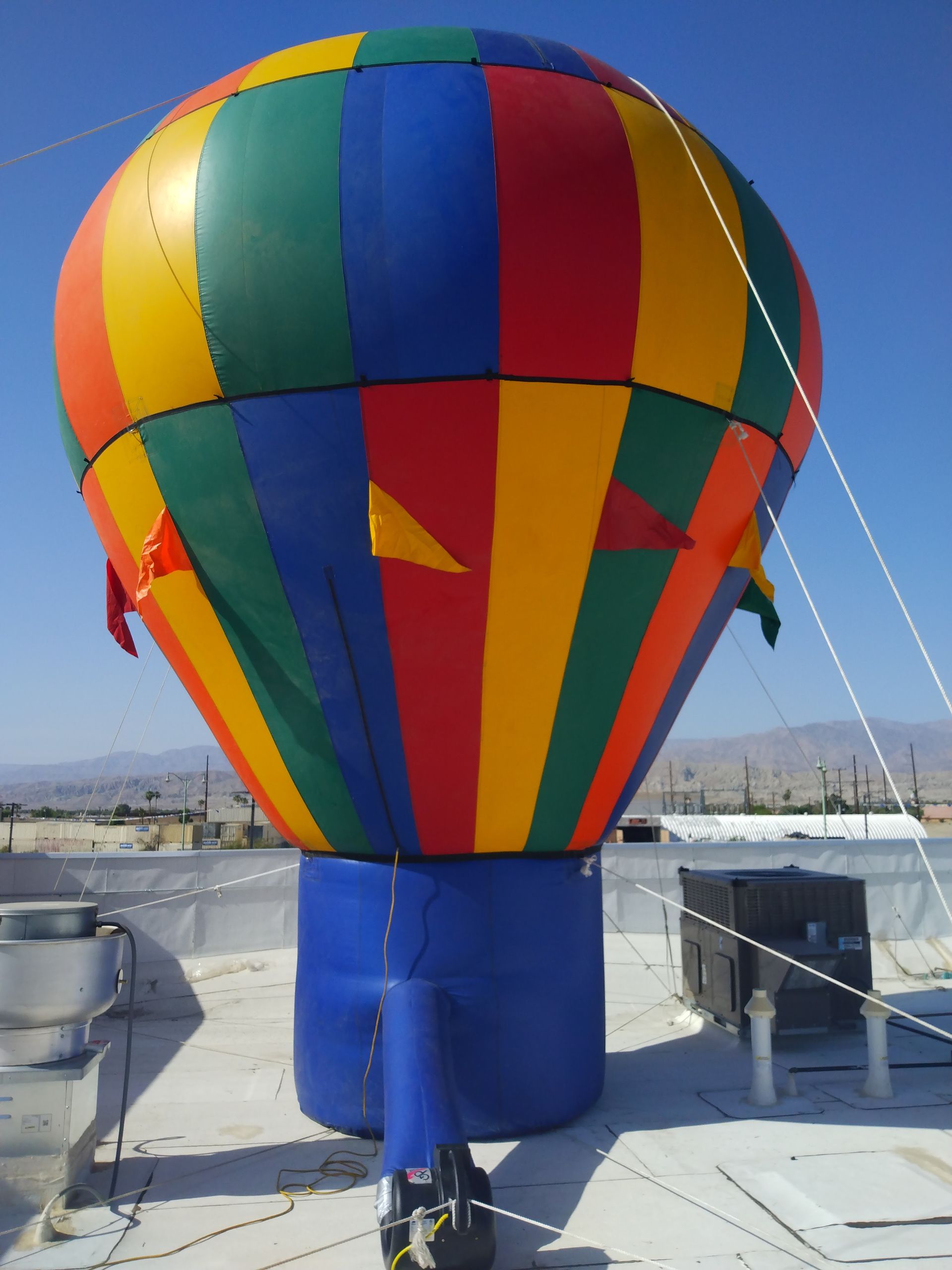 A colorful hot air balloon is sitting on top of a building