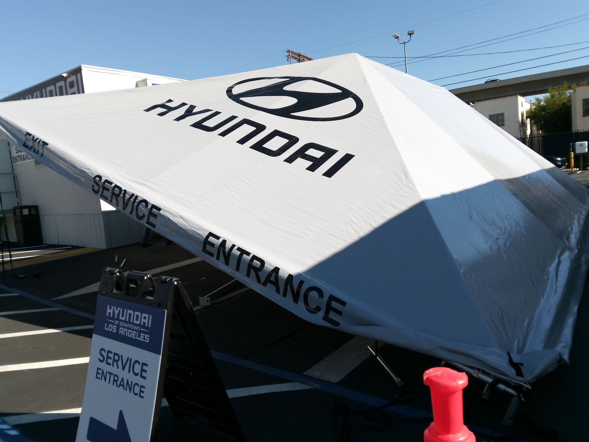 A large white umbrella with the word hyundai on it
