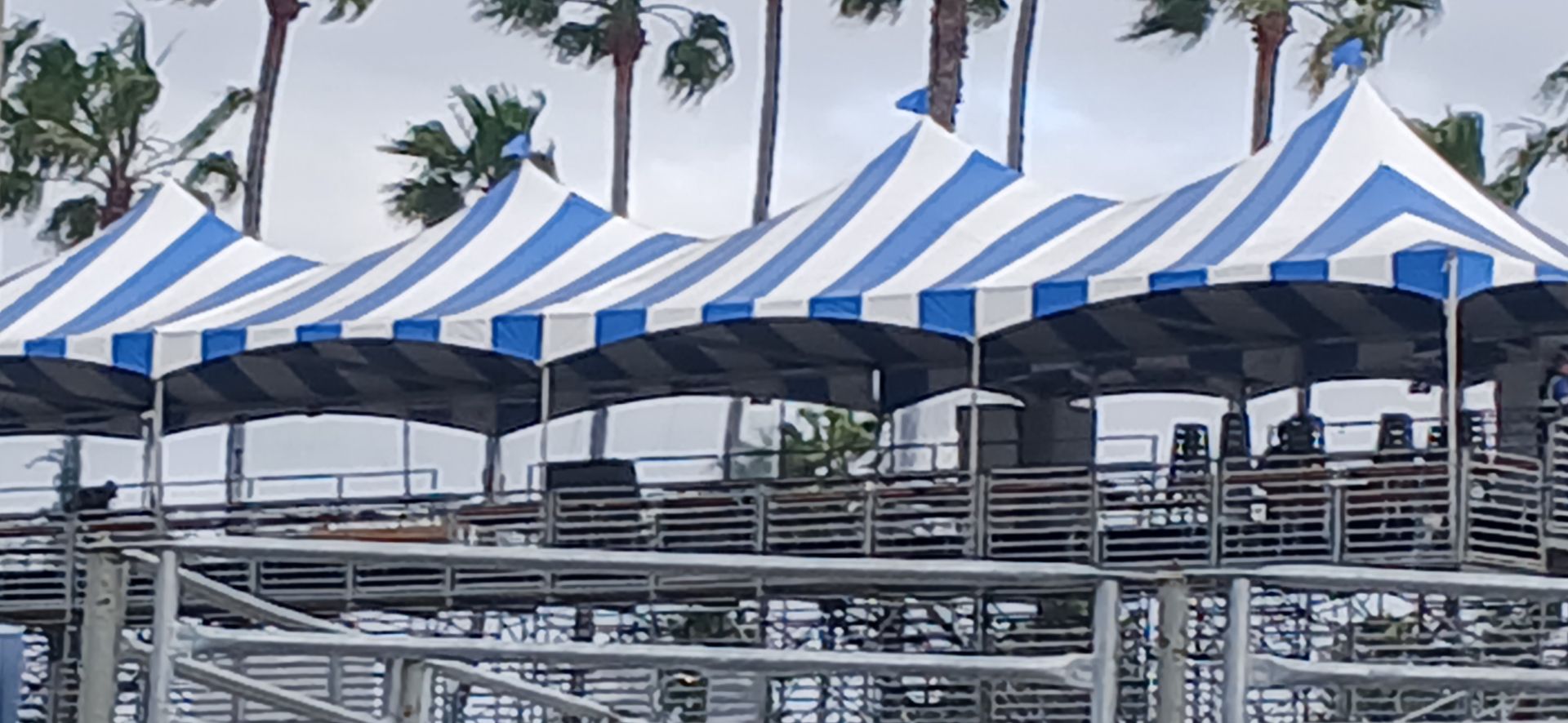 A row of blue and white striped tents are sitting on top of a stage.