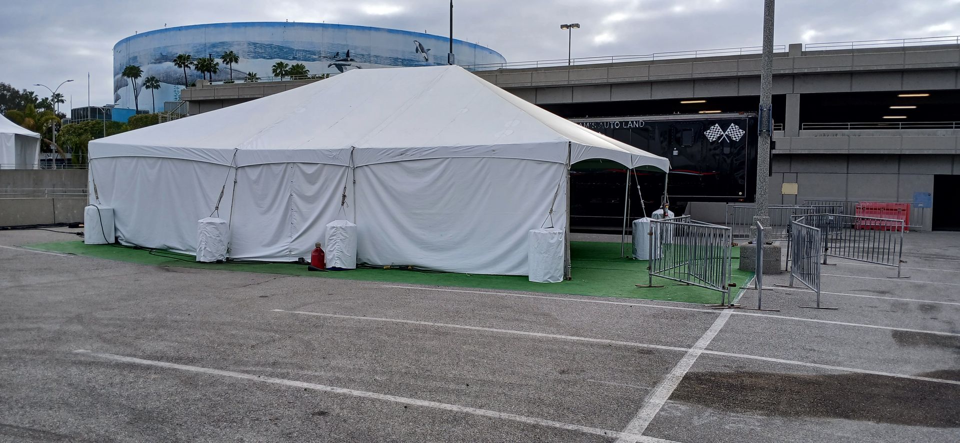 A large white tent is sitting in a parking lot.