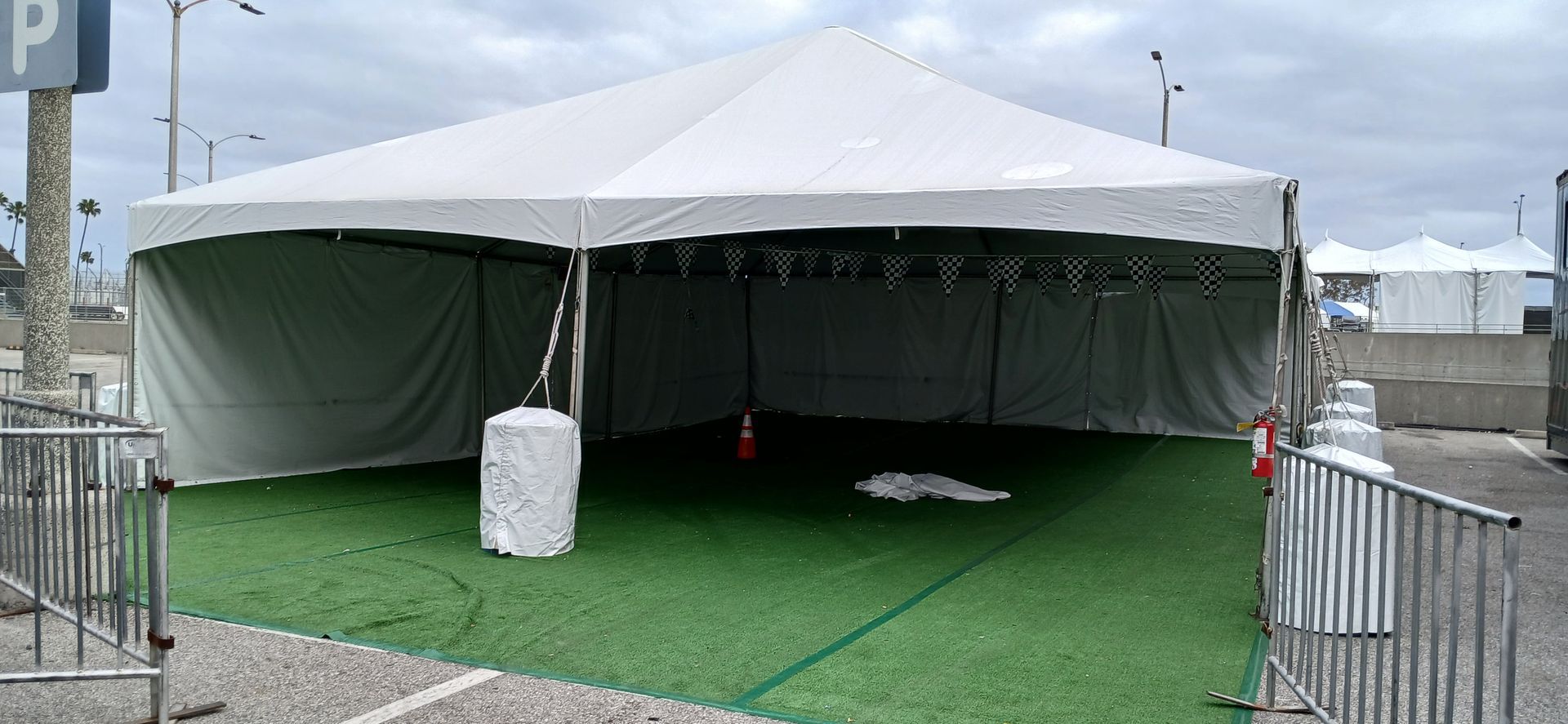 A large white tent is sitting on top of a lush green field.