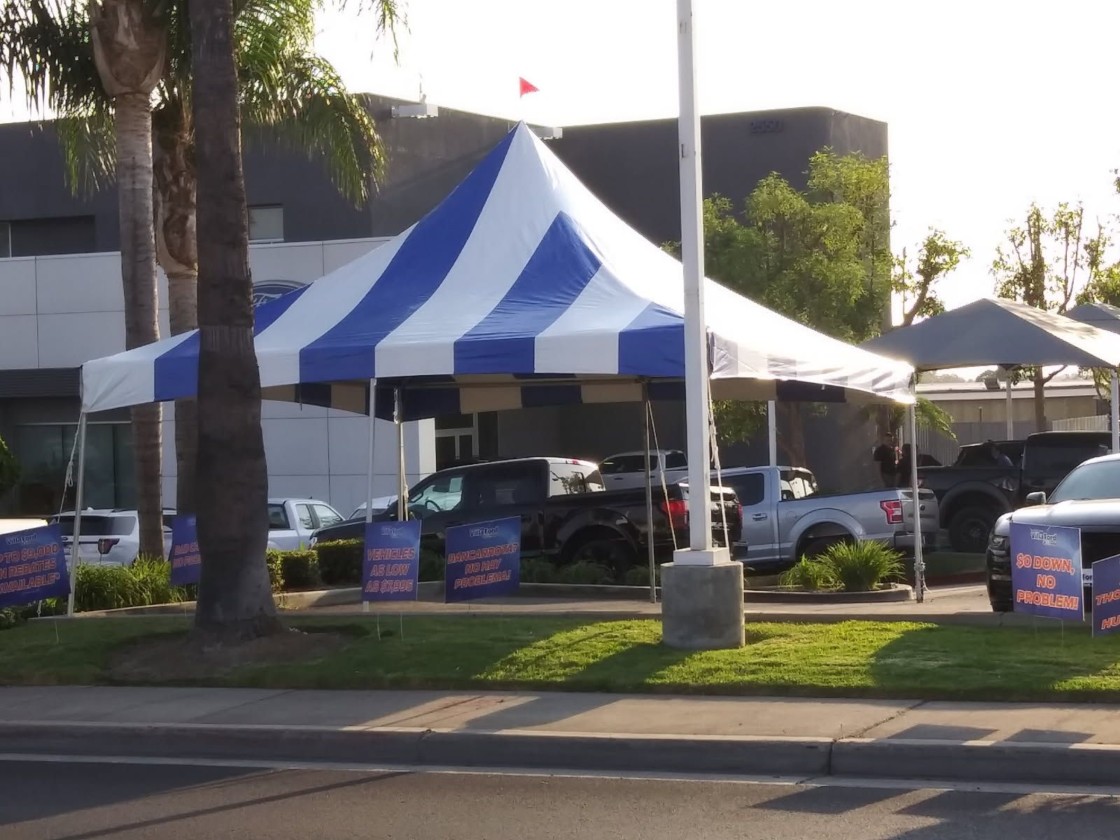 A blue and white tent is sitting on the side of the road