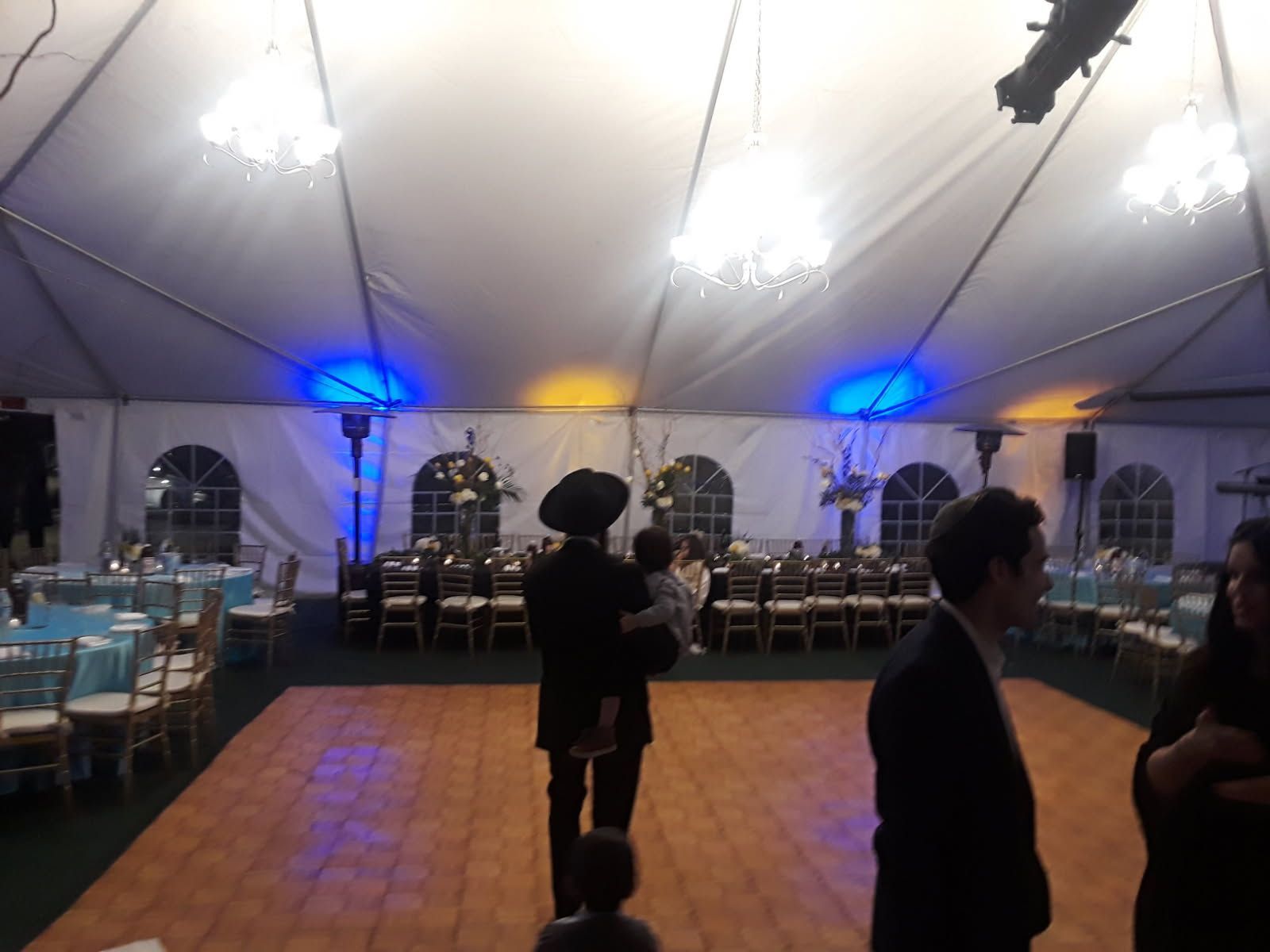 A group of people standing on a dance floor in a tent