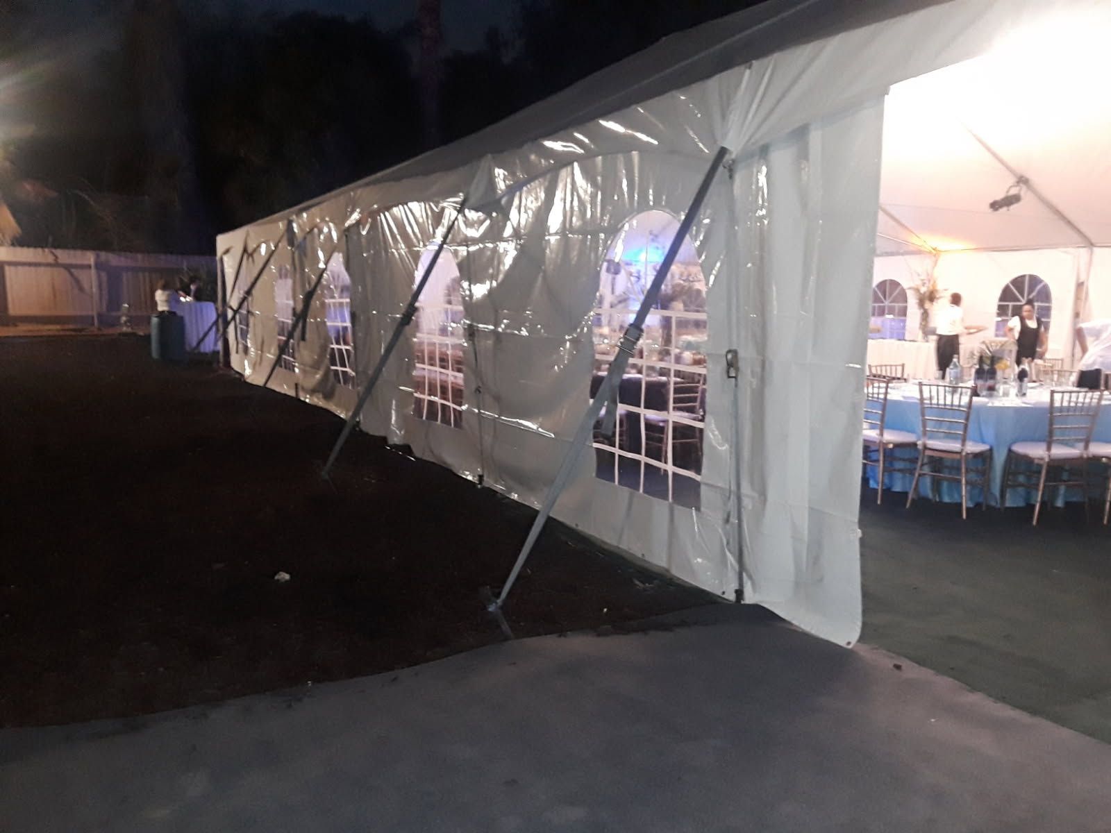 A large white tent with tables and chairs inside of it.