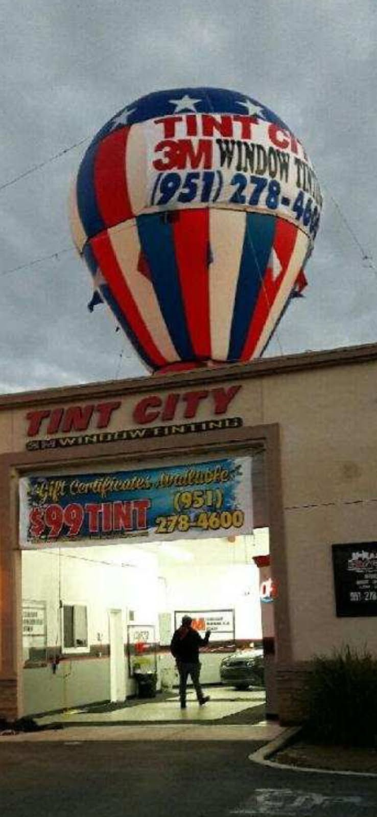 A hot air balloon is flying over tiny city