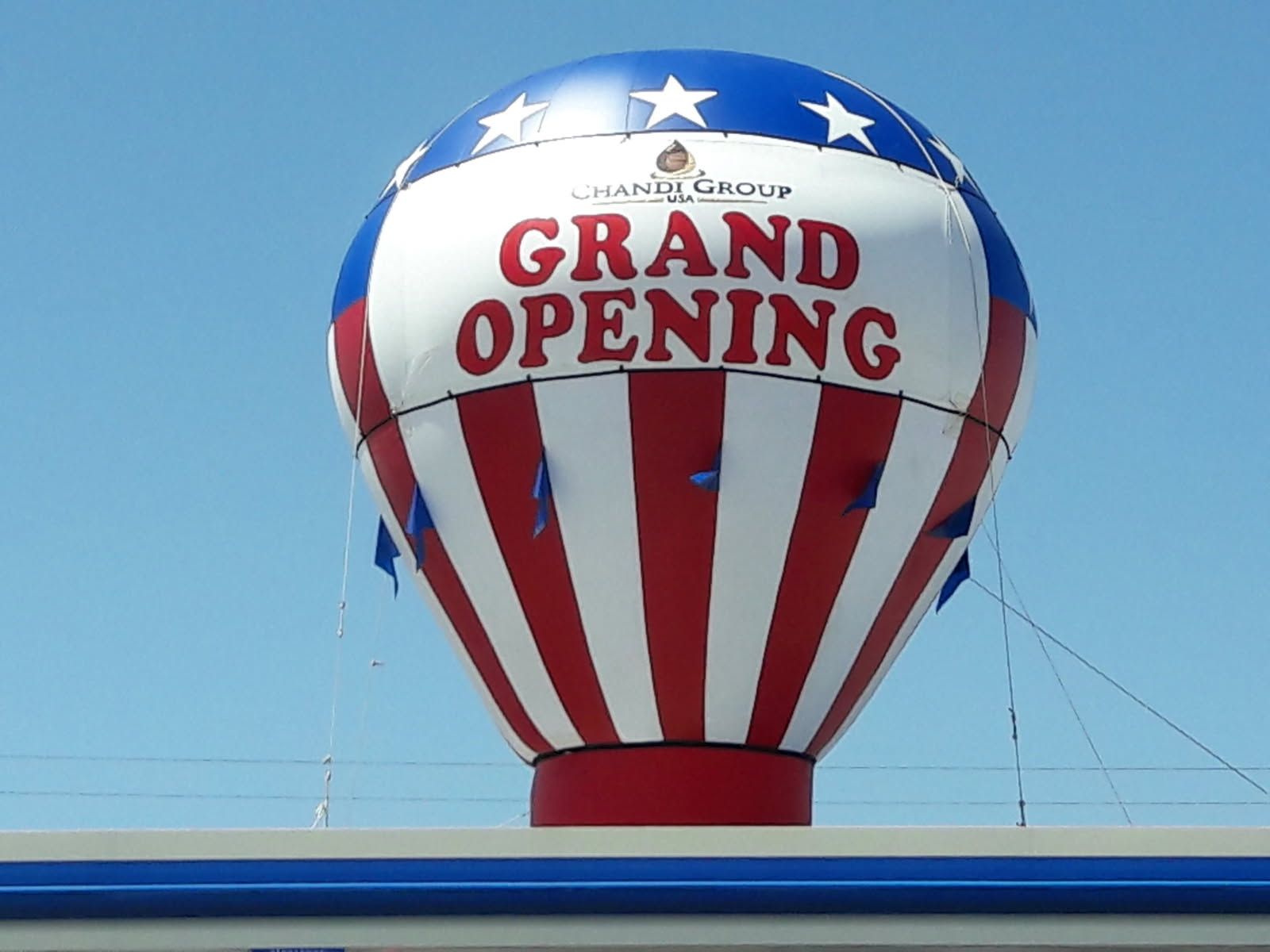 A red white and blue hot air balloon that says grand opening