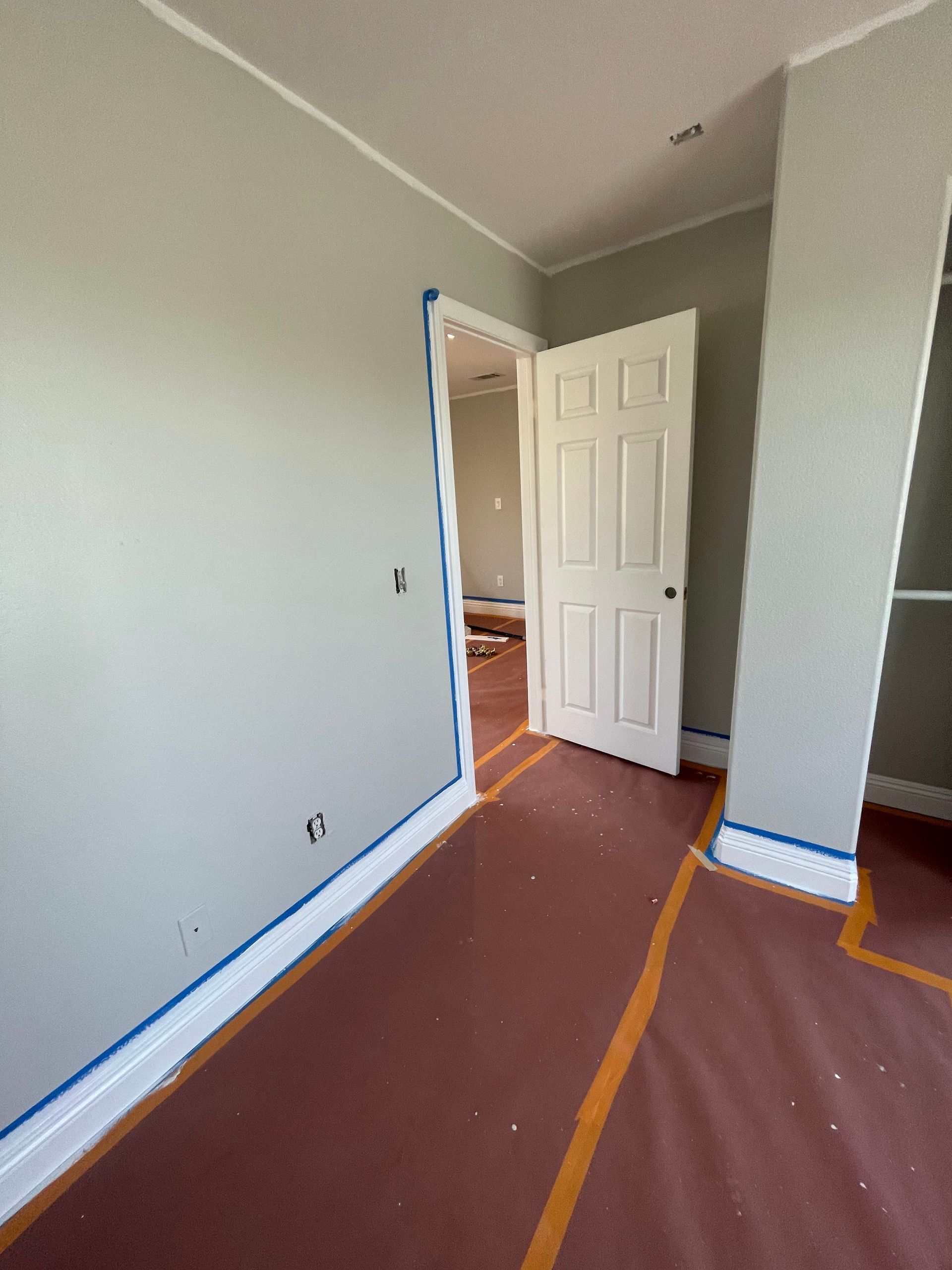 A room that is being painted with a white door