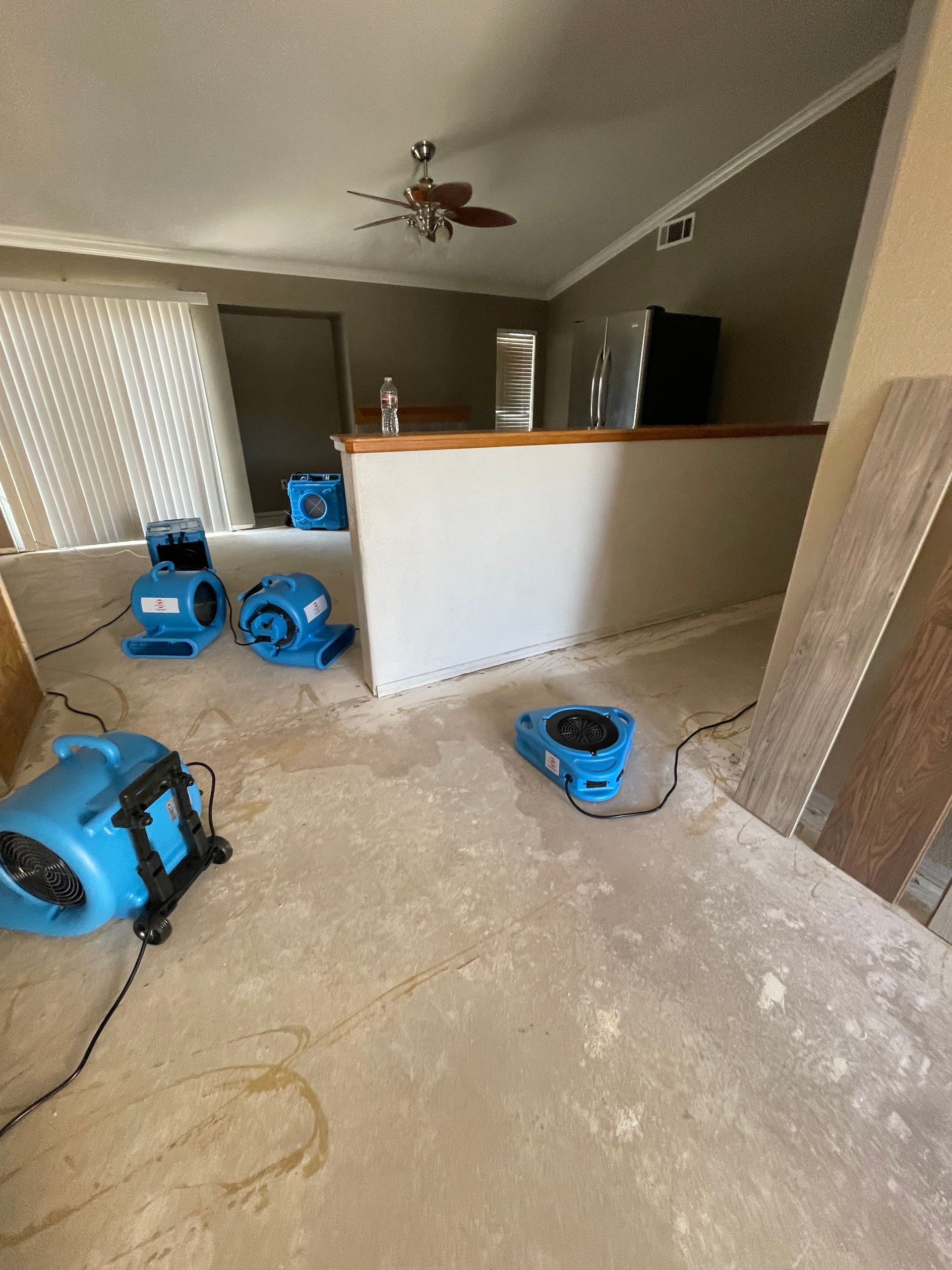 A living room with a lot of appliances on the floor.