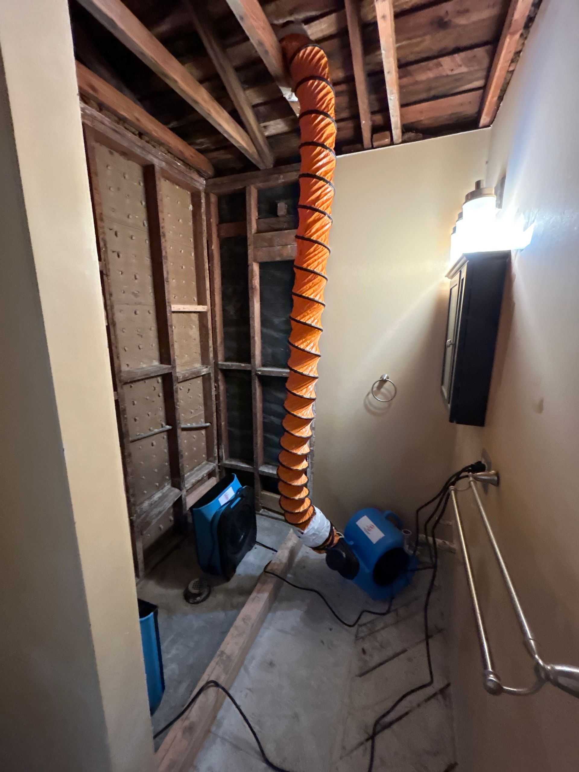 A large orange hose is hanging from the ceiling of a room.