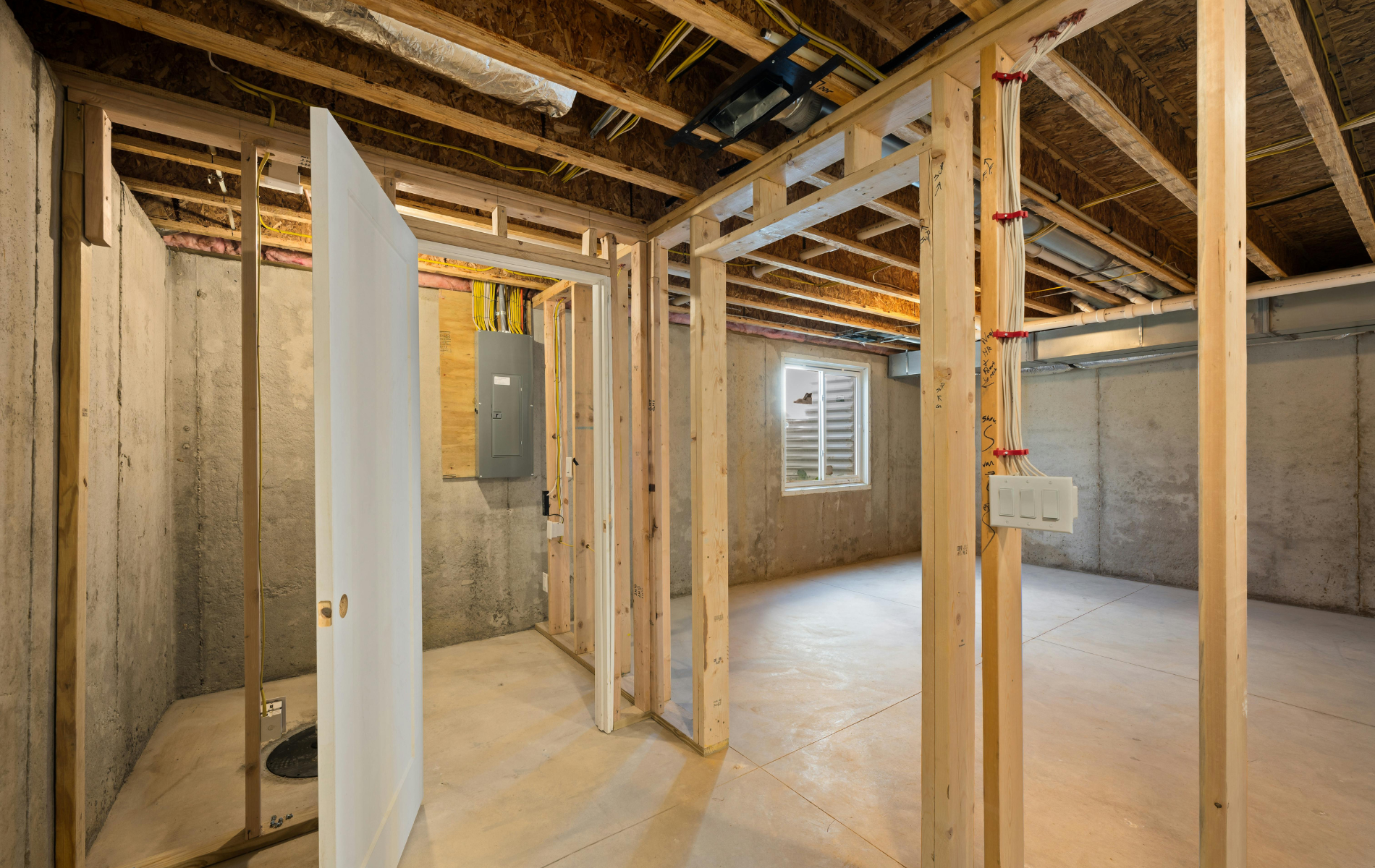A basement under construction with wooden beams and a toilet.