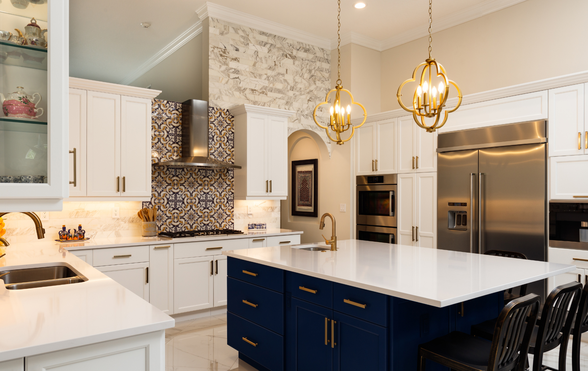 A kitchen with white cabinets , blue cabinets , stainless steel appliances , and a large island.