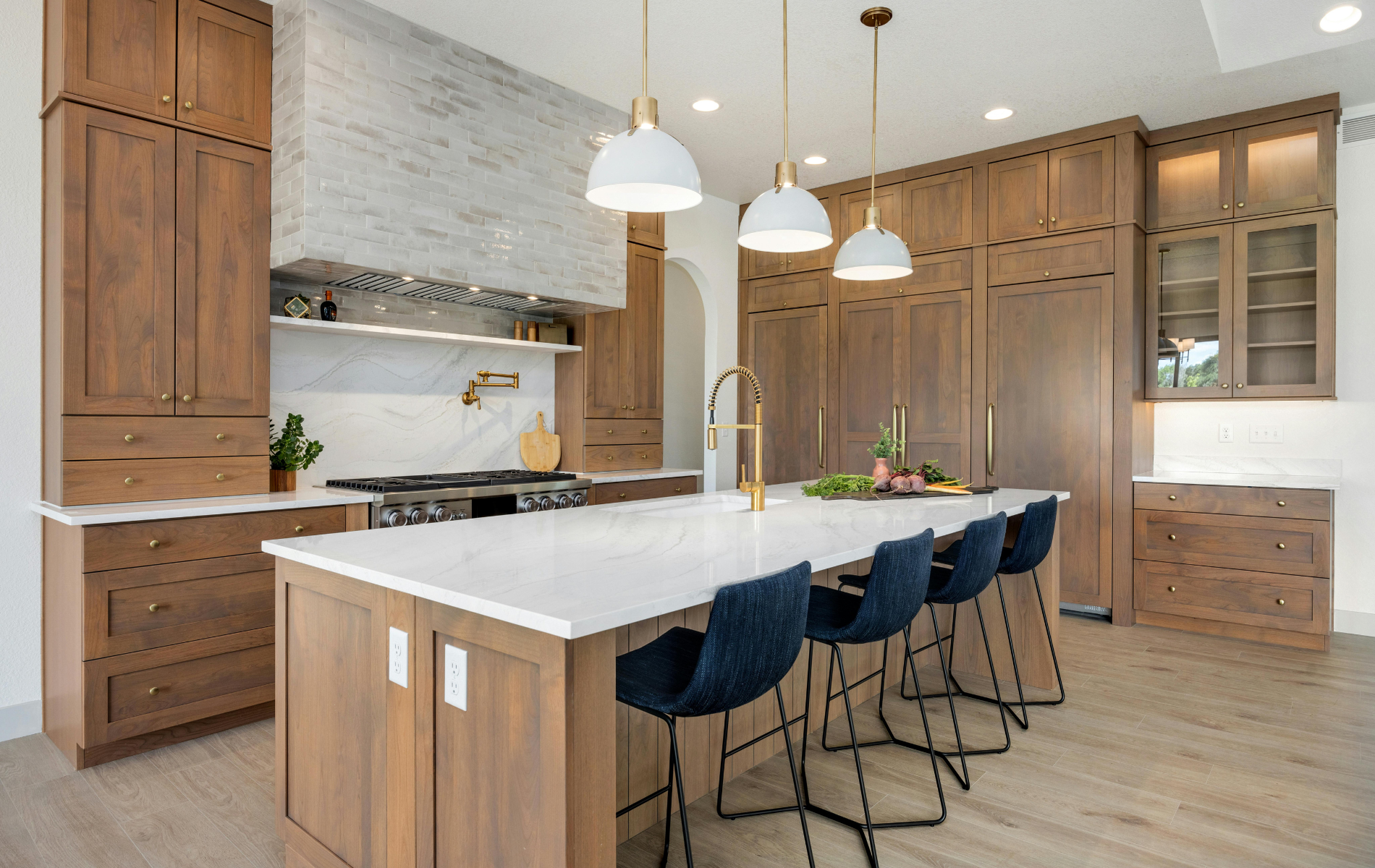 A kitchen with wooden cabinets , white counter tops , and a large island.