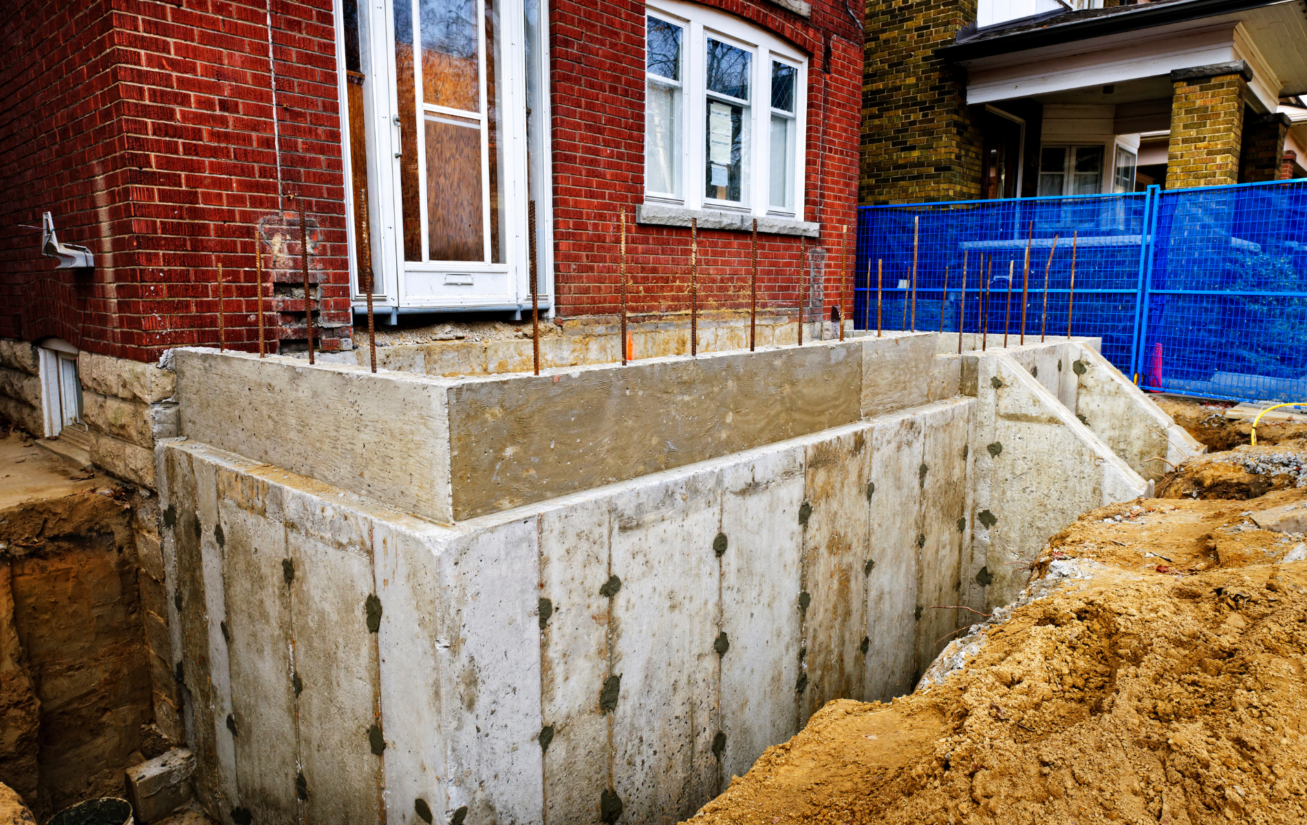 A brick house with a concrete basement under construction.