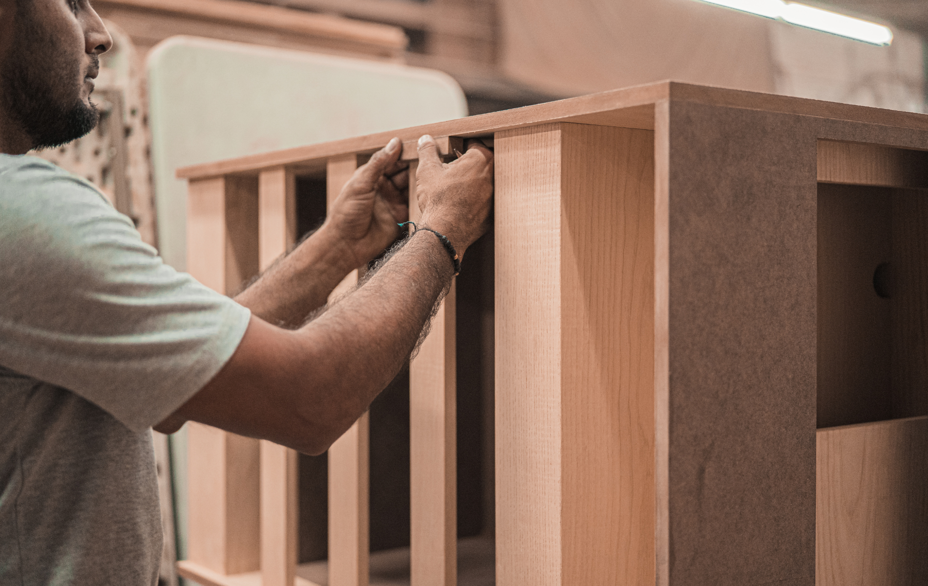 A man is working on a piece of wood in a workshop.