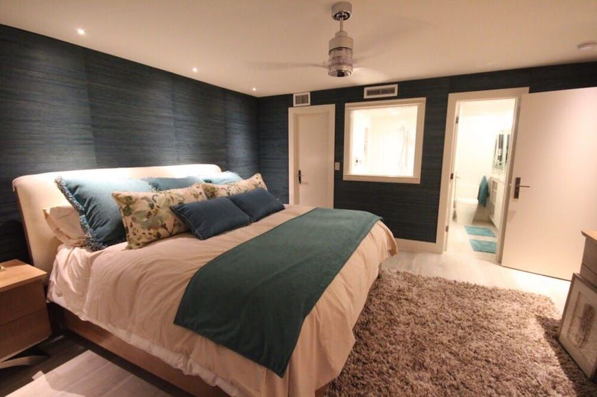 A bedroom with a large bed and a ceiling fan