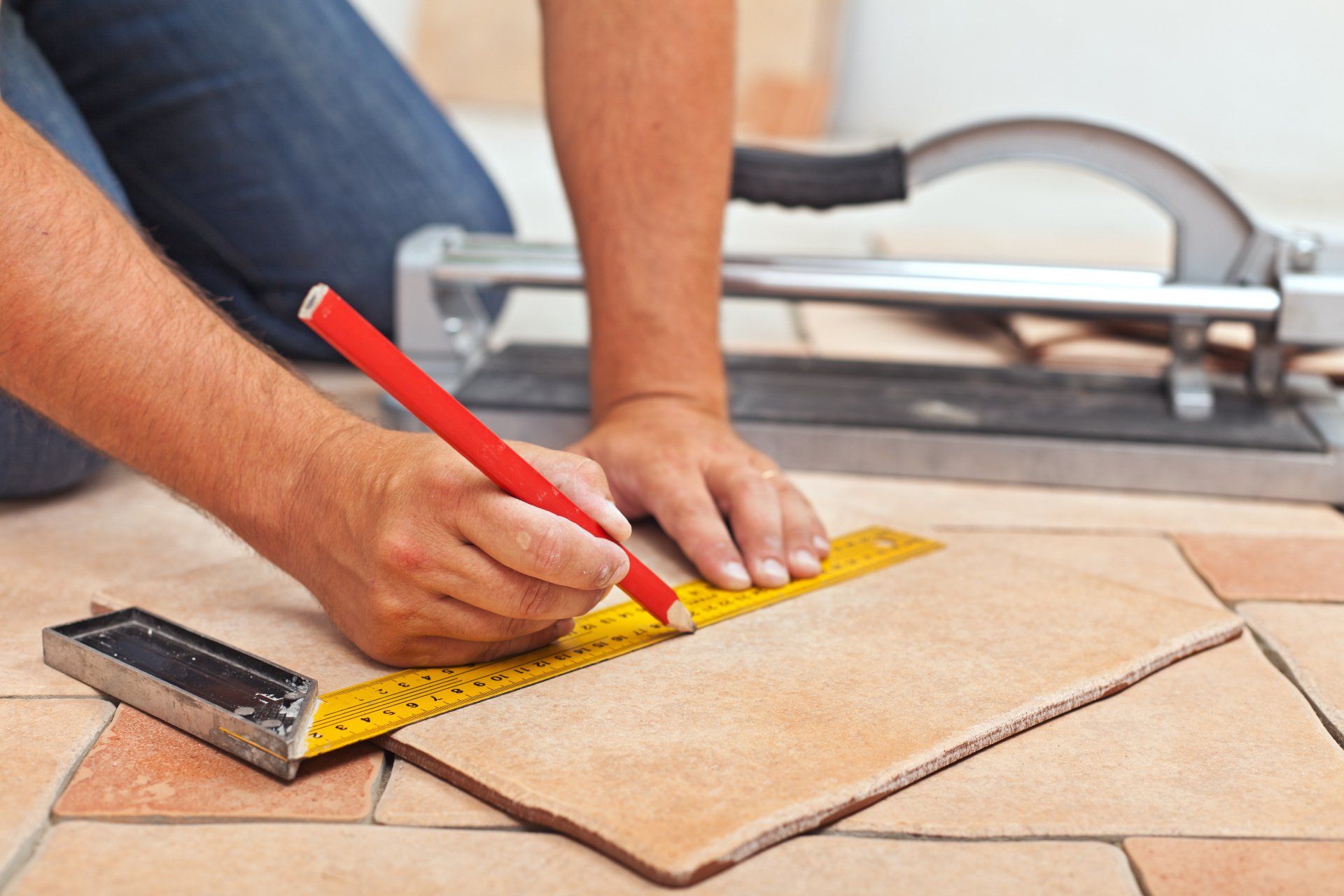 Man's hands carefully placing ceramic floor tiles during home renovation.