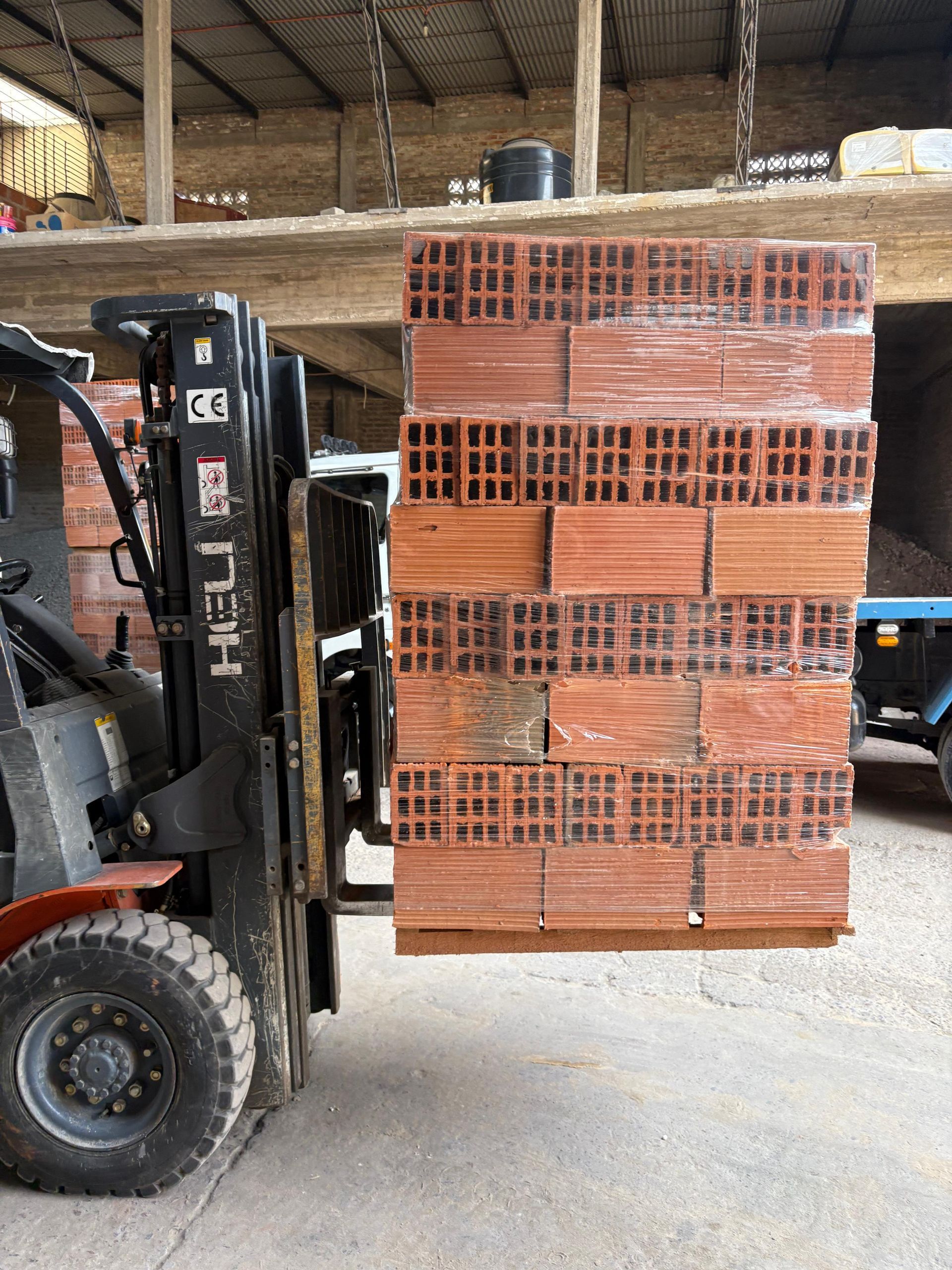 materiales de construcción: bloques de hormigón, ladrillos, varillas de acero y rollos envueltos en plástico.