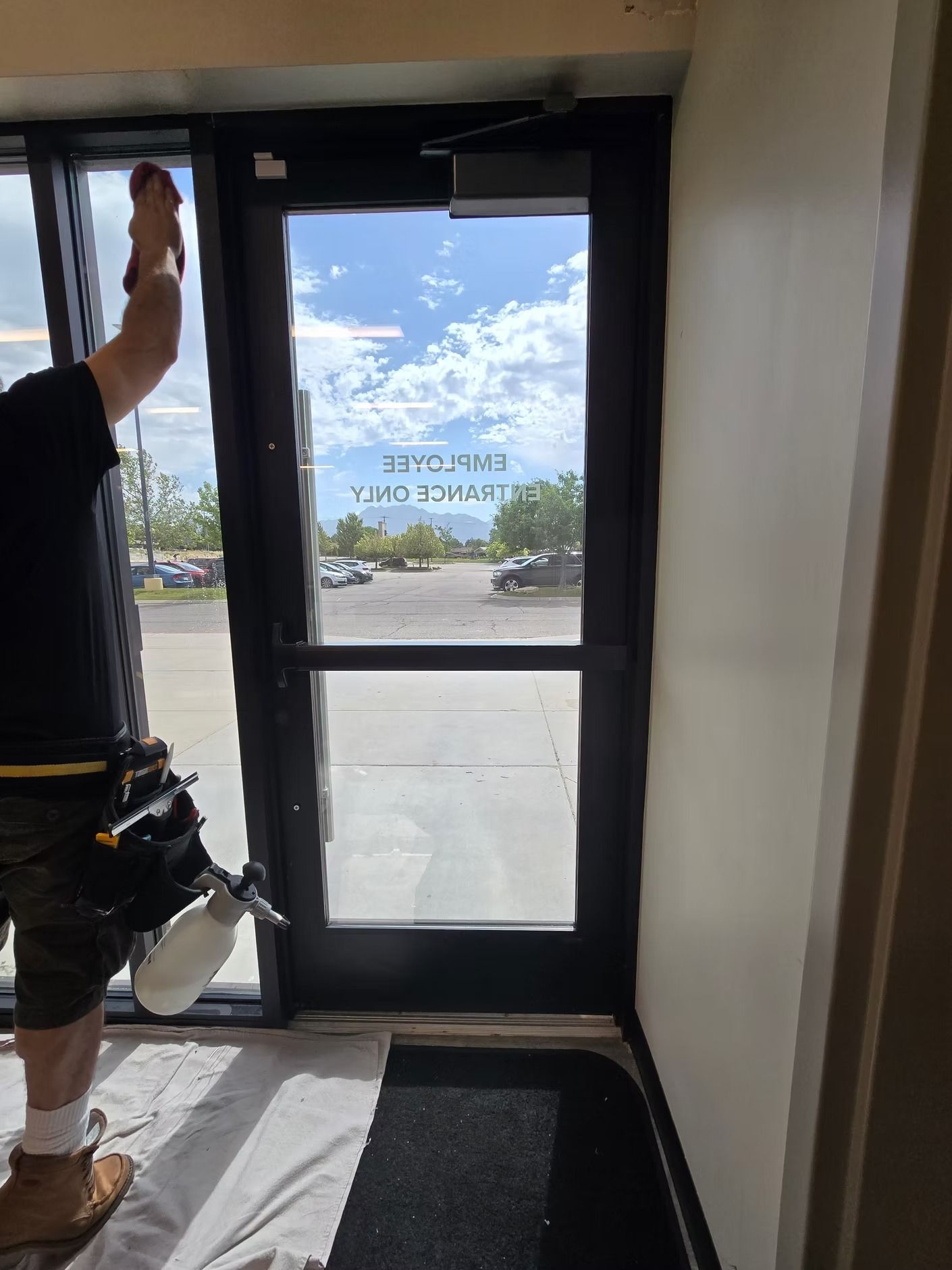 A man is cleaning a black car with a cloth.