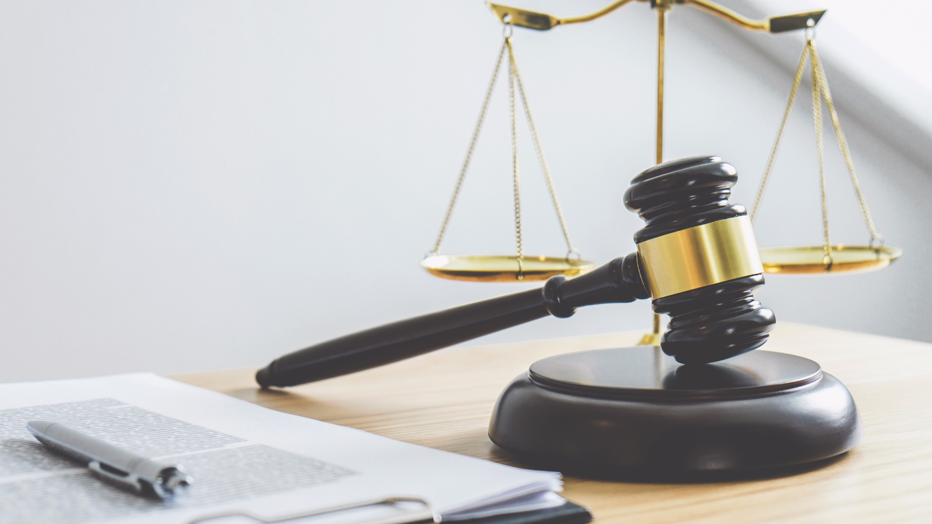 A lawyer is sitting at a desk writing on a clipboard.