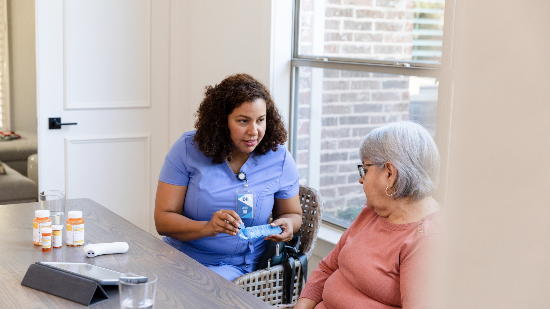 a nurse is talking to an elderly woman at a table .
