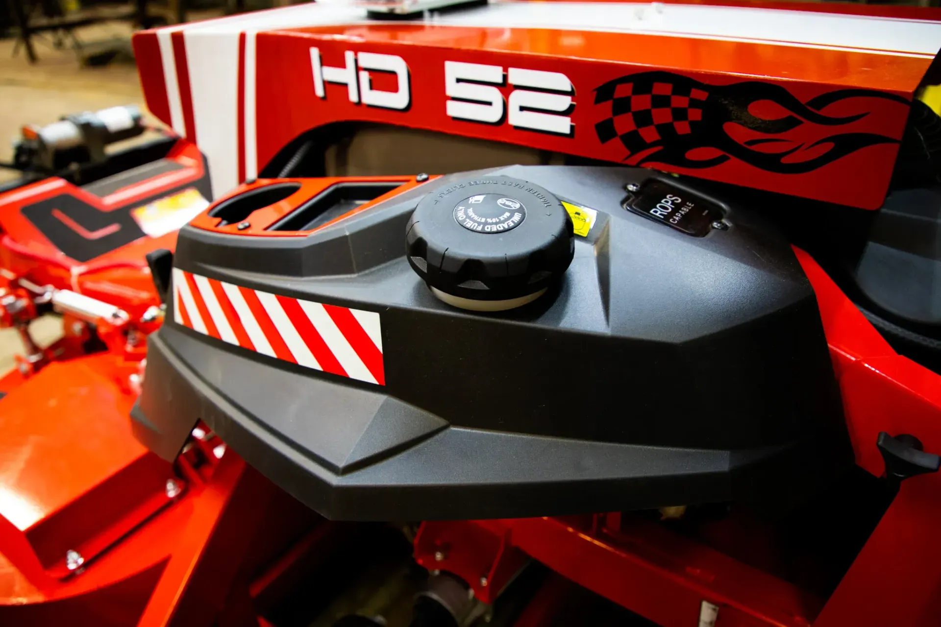 Red and black HD 52 lawn mower details with fuel cap, striped trim, and racing graphics.