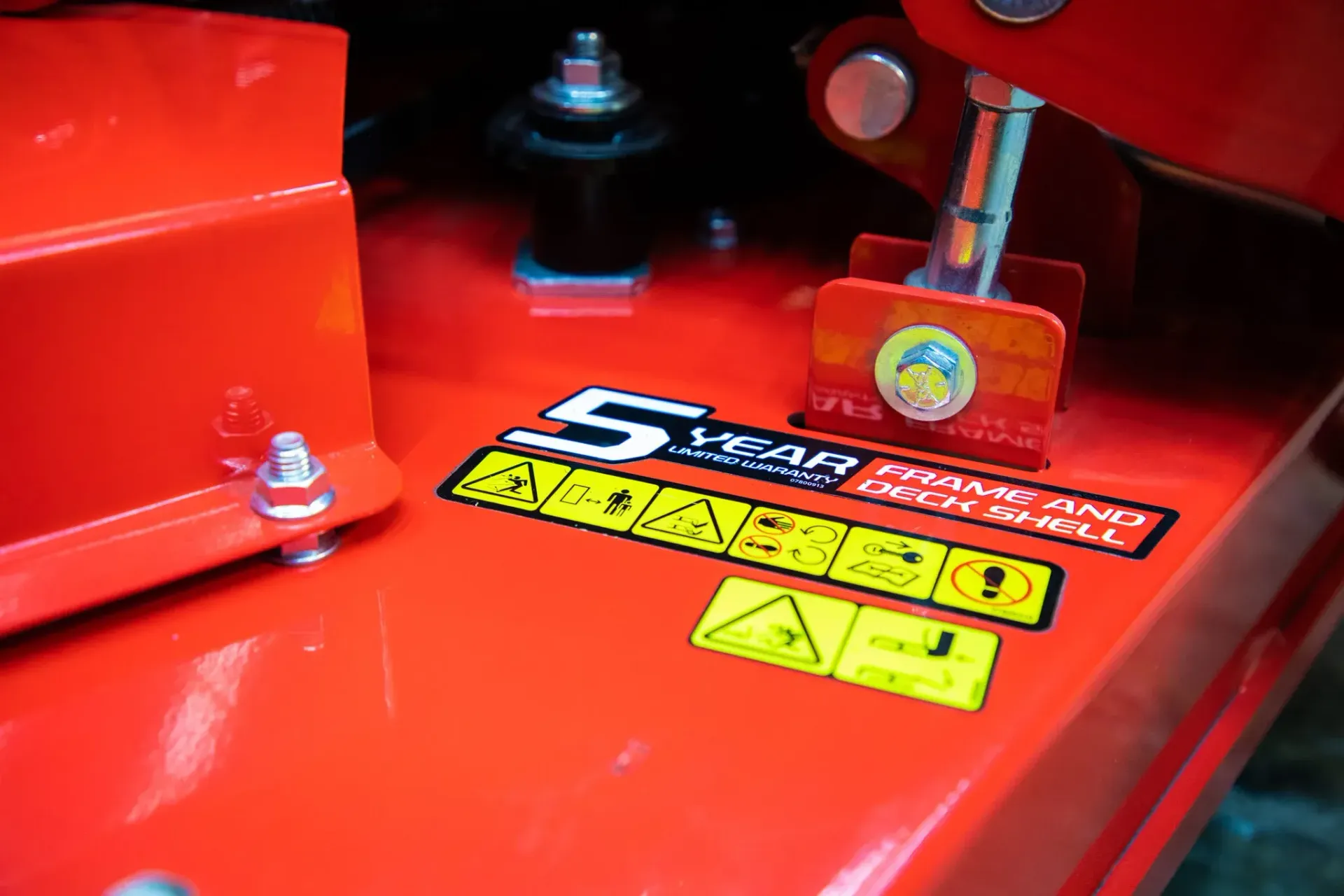Red machinery deck with warning stickers and safety instructions.