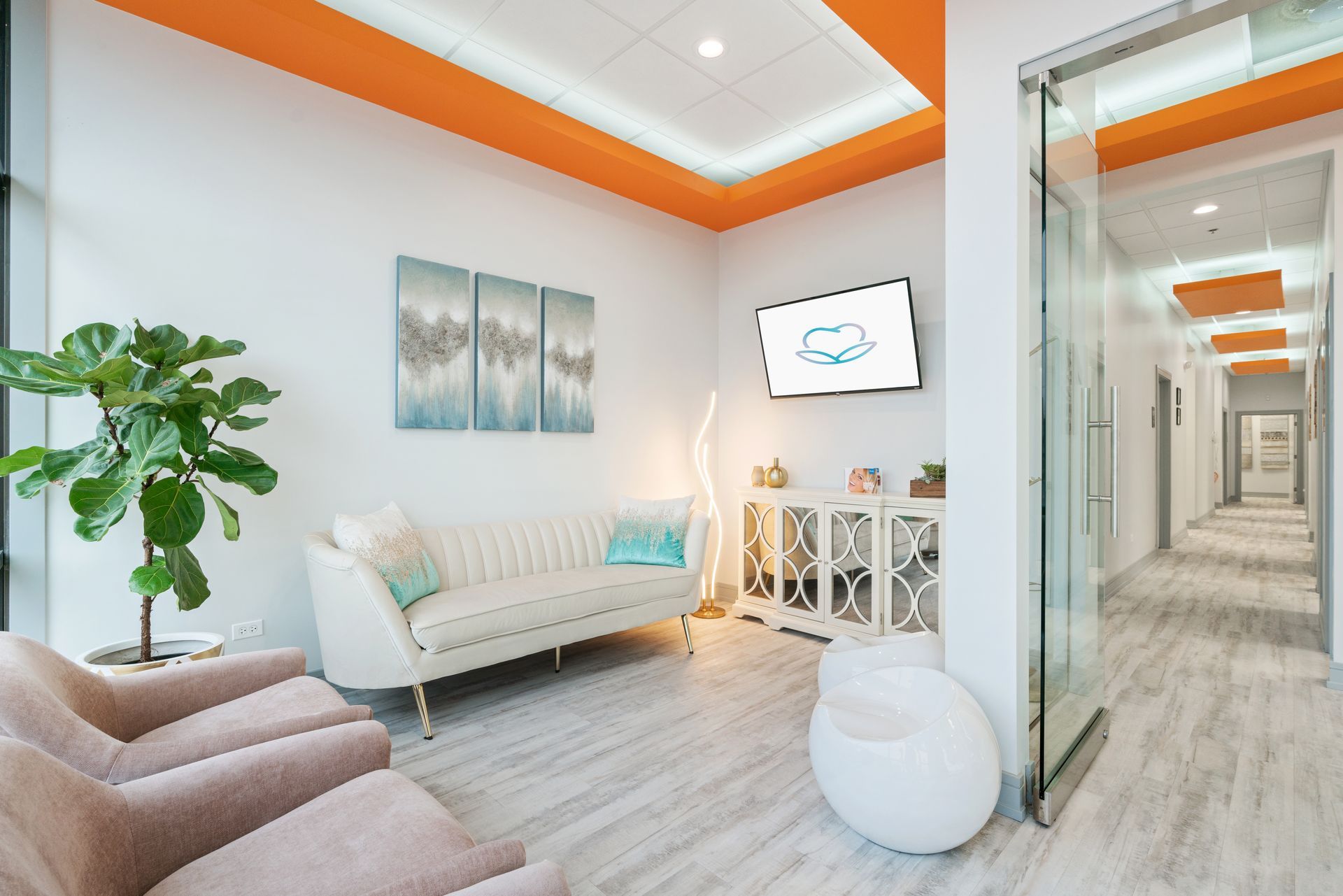 A waiting room with a couch , chairs , and a television.