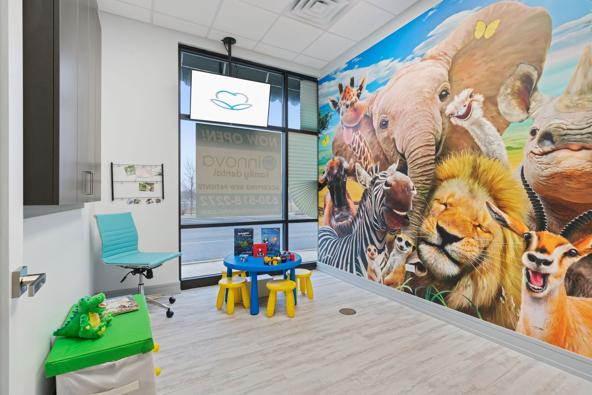 A room with a mural of animals on the wall and a table and chairs.