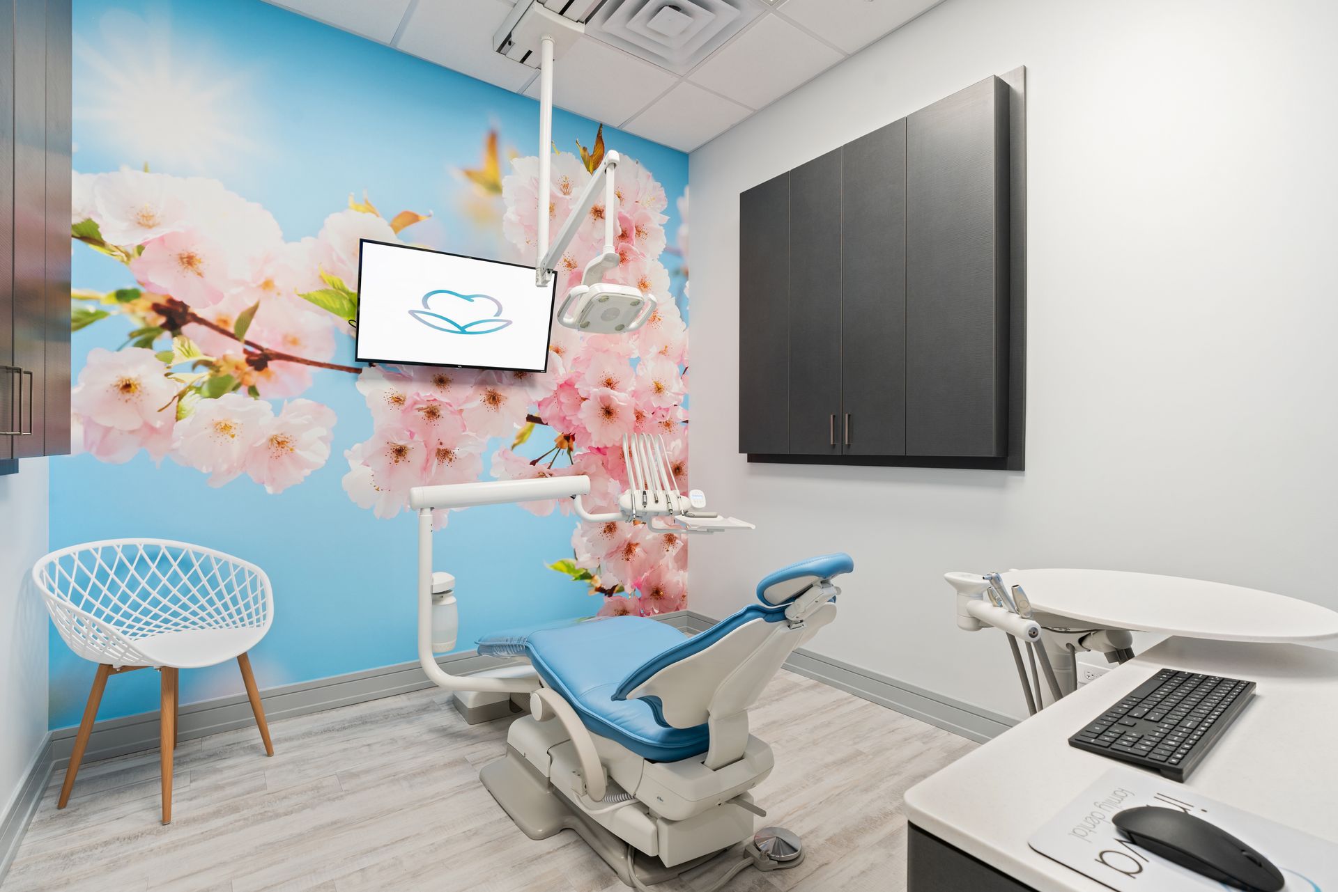 A dental office with a cherry blossom wallpaper on the wall.