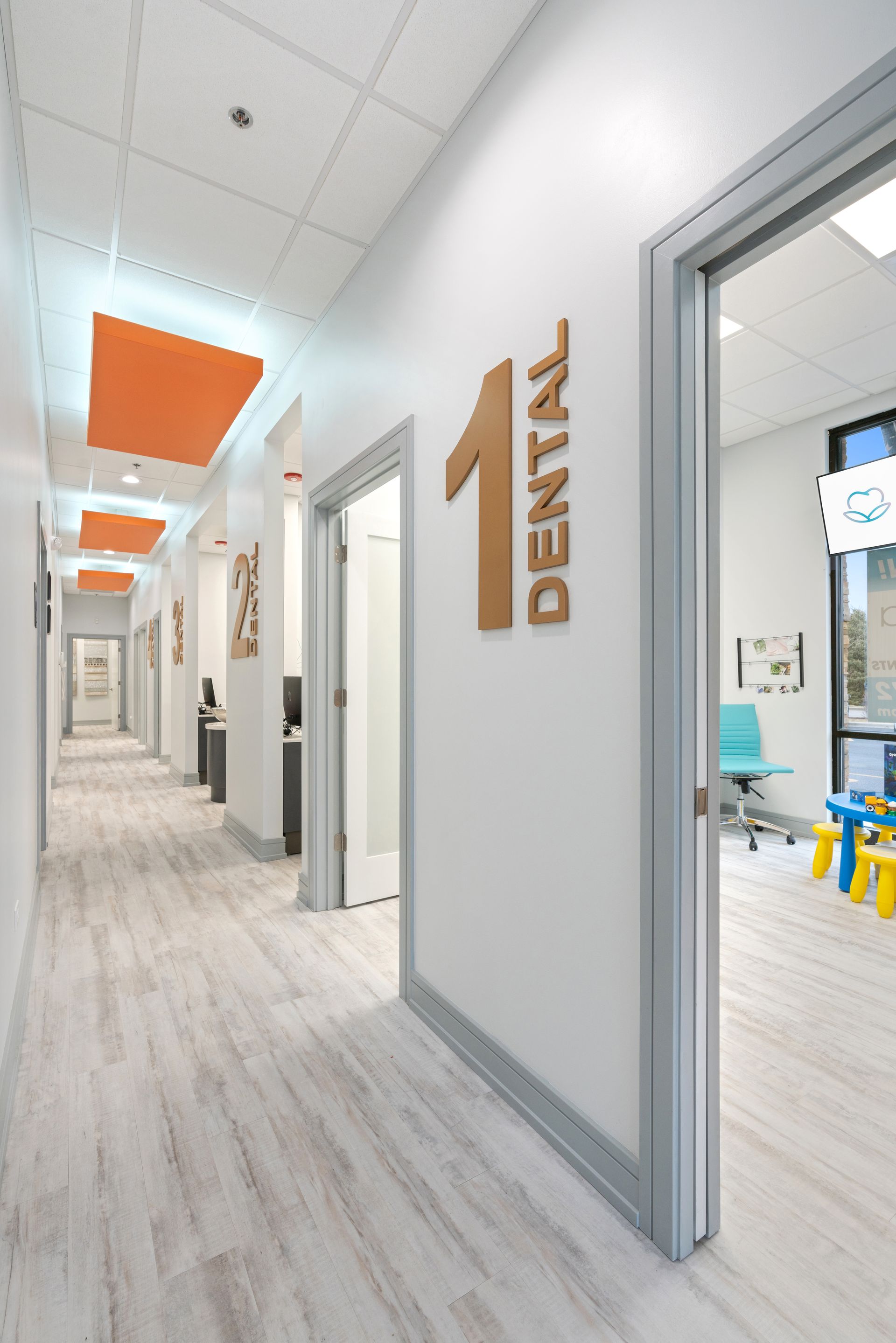 A long hallway in a dental office with a sign on the wall that says dental.